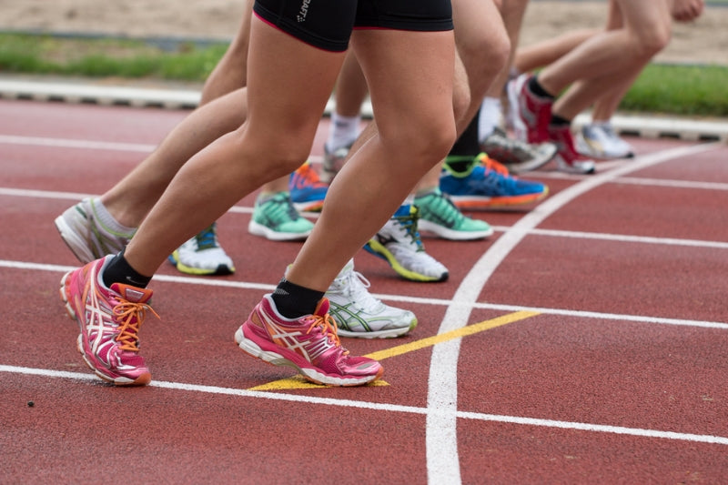 A group of people running a marathon on a plastic track