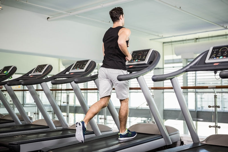 A man running on a treadmill wearing Hywell running socks