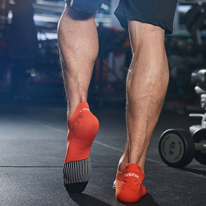 Athlete wearing red running ankle socks with a secure fit for active workouts and runs.
