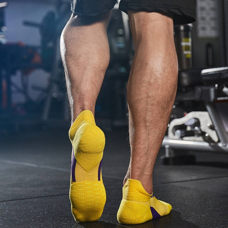 Athlete wearing thick padded running socks in yellow for optimal support and impact absorption.
