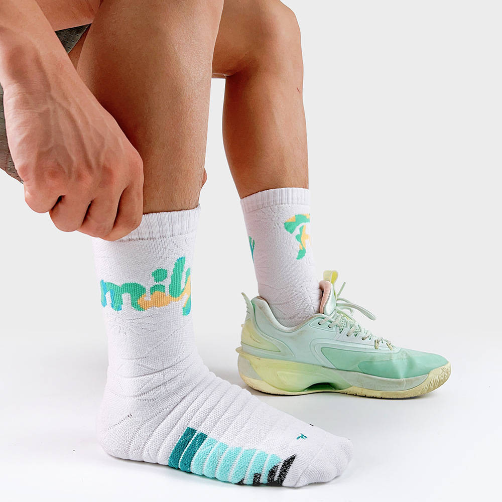 Athlete wearing white padded socks with teal stripes, ideal for training or everyday wear.