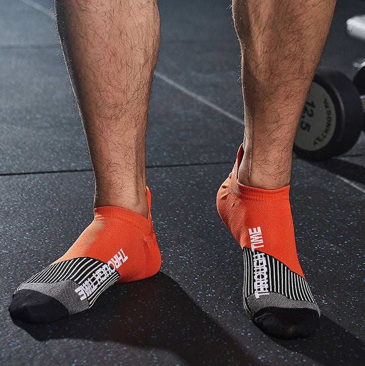 Close-up of orange running ankle socks with moisture-wicking fabric and sleek design.