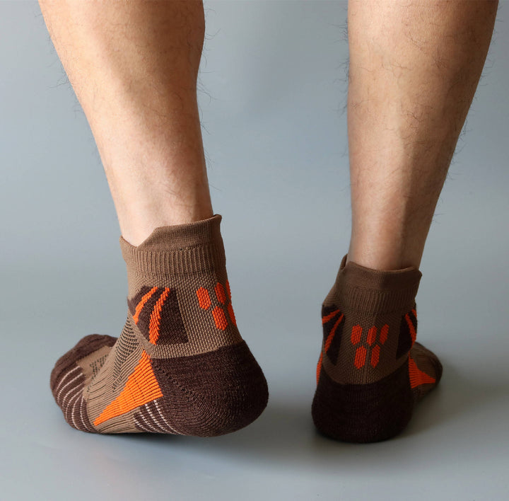 Dark brown tennis ankle socks worn on feet, designed for stability and sweat control.