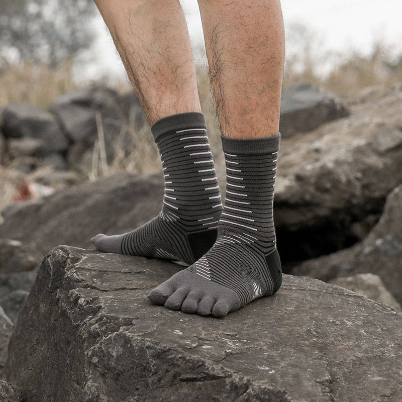 Gray anti blister toe socks on rocky terrain, built for trail runs and outdoor activity with blister protection.