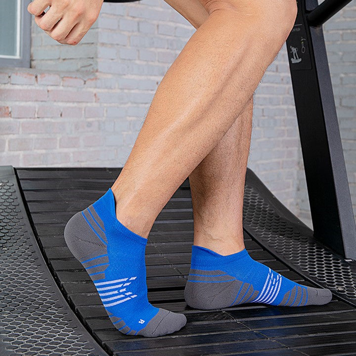 Men wearing blue thin running socks while running on a treadmill