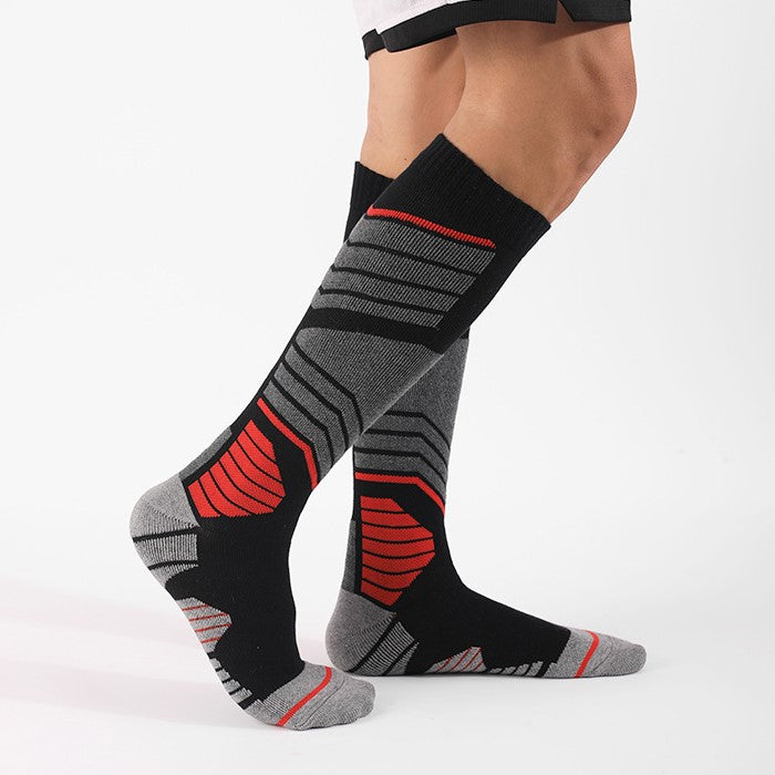 Skier wearing thick padded skiing over the calf socks in black and red for extra support and comfort
