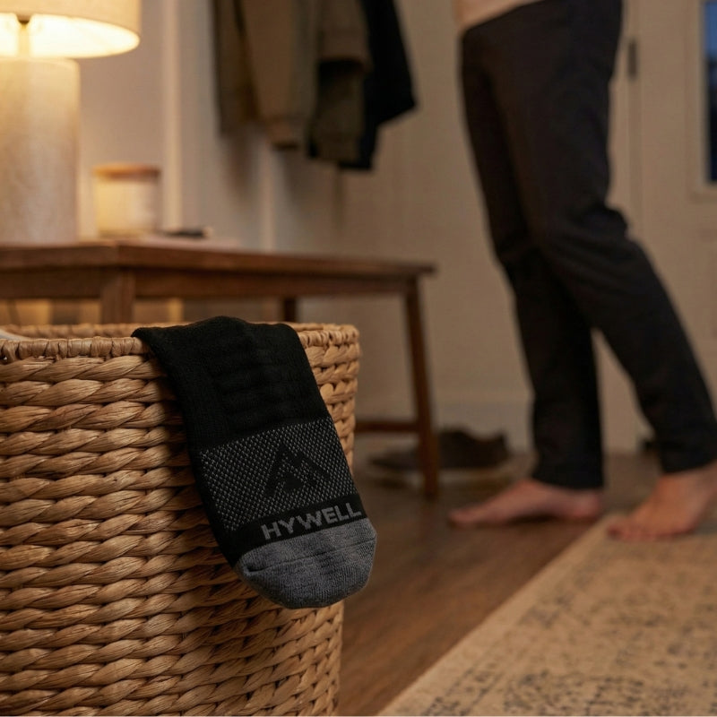hywell merino wool socks no-show style draped over a laundry basket after a full day of wear with the toe logo visible