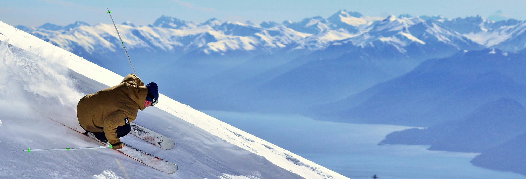 Skier making a sharp turn on a snowy mountain slope.