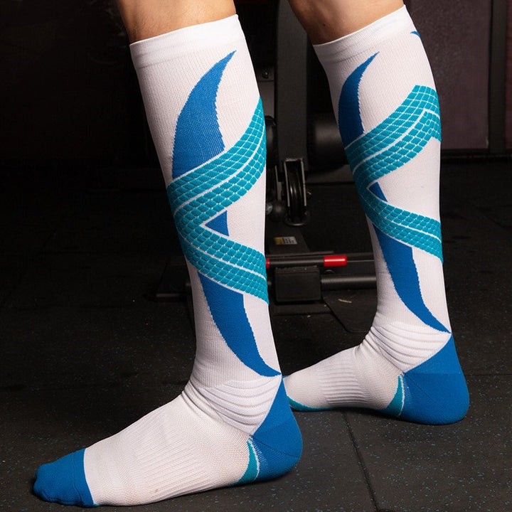 A person wearing white compression socks with blue geometric patterns standing in a workout room